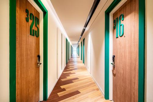a corridor of a hospital with wooden doors at Hotel Amber Pattaya in Pattaya Central