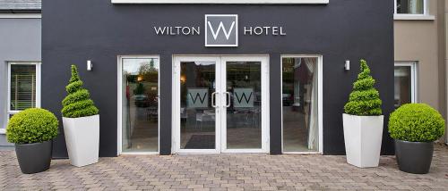 a entrance to a hotel with two potted trees in front at Wilton Hotel Bray in Bray