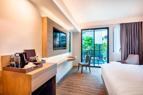 a hotel room with a bed and a view of a balcony at Hotel Amber Pattaya in Pattaya Central