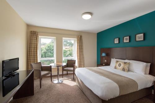 a hotel room with a large bed and a television at Wilton Hotel Bray in Bray