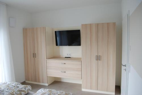 Un dormitorio con un mueble con un televisor encima. en Starenweg Appartements, en Langenargen