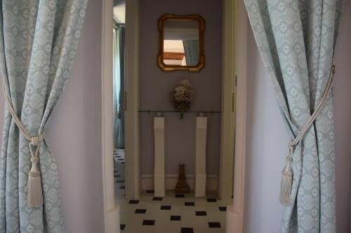 a hallway with blue curtains and a mirror at Villa Laura in Savoca 