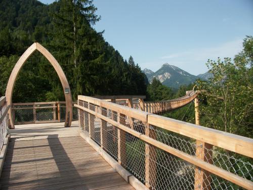 a wooden suspension bridge with a view of the mountains at Haus Alpenrose in Schwangau