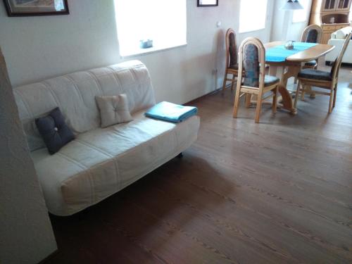 a living room with a white couch and a table at Jurahaus Maisonette Wohnung in Solnhofen