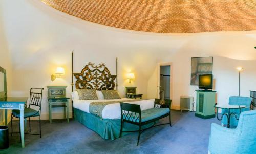 a bedroom with a bed and a table and chairs at Palacio de los Velada in Avila