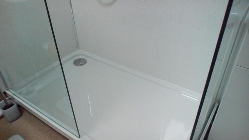 um chuveiro com uma porta de vidro na casa de banho em The Lincolnshire Poacher Inn em Metheringham