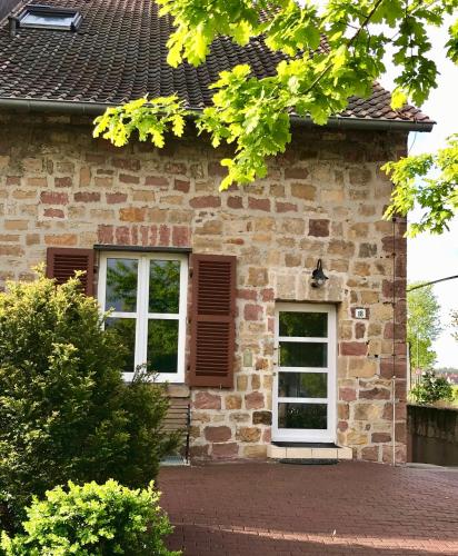 a brick house with two windows and a roof at Gästehaus & Café Leeze in Bad Dürkheim