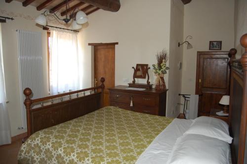 a bedroom with a bed and a dresser and a window at Agriturismo Podere Ranciano Alto in Castiglione del Lago