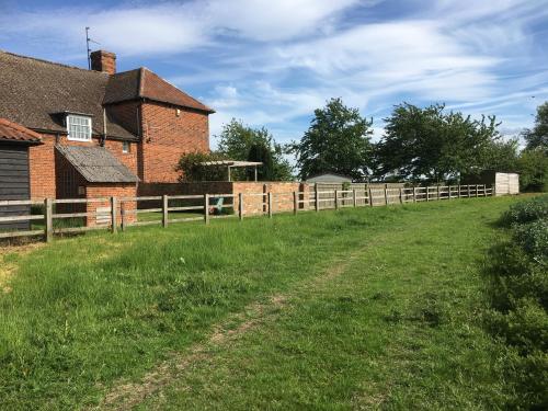 a fence in a field next to a house at The Stables Kings Ripton in Huntingdon