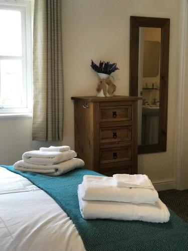 three towels are stacked on a bed in a bathroom at The Stables Kings Ripton in Huntingdon
