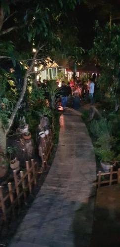 a path in a garden at night with people walking down it at Garden Homestay in Di Linh