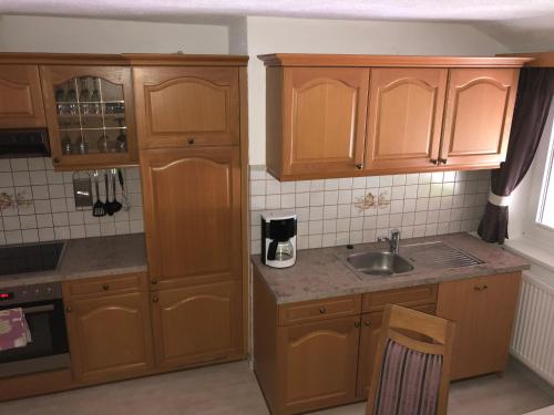 a kitchen with wooden cabinets and a sink at Haus am Wald in Neustift im Stubaital