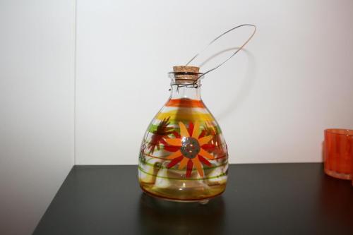 a glass bottle with a flower in it on a table at Tjeldsundbrua Hotel in Evenskjer