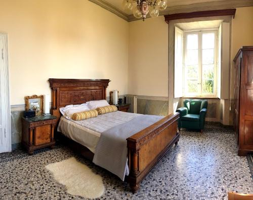 a bedroom with a bed and a chair and a window at Villa CALVI Lago Maggiore in Premeno