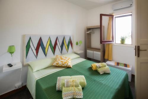 a bedroom with a green bed with two pillows at Bella Vista b&b in Erice