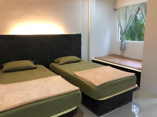 a room with two beds and a window at chillchillsangkhlaburi โรงแรมชิลชิลสังขละบุรี in Sangkhla Buri