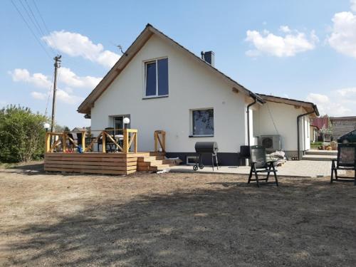 a white house with a porch and a patio at Kaimo Vila “Padange” in Kančėnai