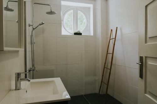 a white bathroom with a sink and a window at Five Seven Nine Apartments in Porto