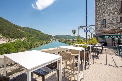 a row of tables and chairs next to a river at Hôtel de la Citadelle in Sisteron