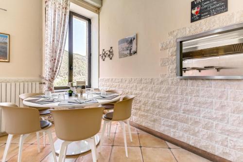 a dining room with a table and chairs and a tv at Hôtel de la Citadelle in Sisteron