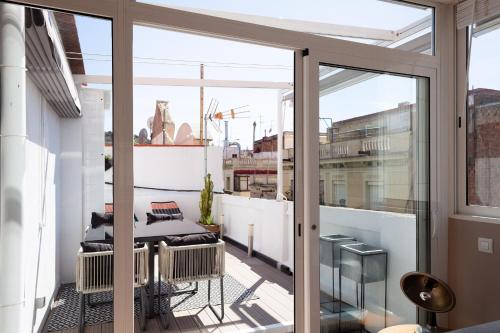 balcón con vistas a la ciudad a través de puertas de cristal en Brummell Apartments Poble Sec en Barcelona