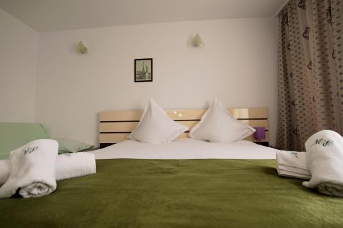 a bedroom with a large bed with towels on it at Vila Pretty Woman in Eforie Nord