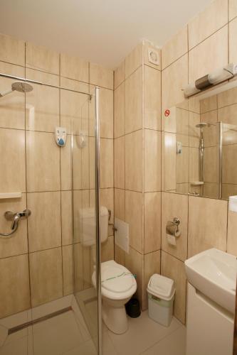 a bathroom with a toilet and a glass shower at Vila Pretty Woman in Eforie Nord