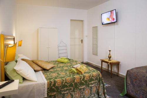 a hotel room with a bed and a television on the wall at Bella Vista b&b in Erice