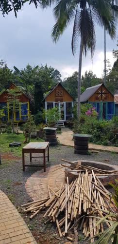 a park with a bench and a table and a building at Garden Homestay in Di Linh