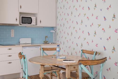 a kitchen with a wooden table and two chairs at Aires da Serra Hotel in Torres Novas