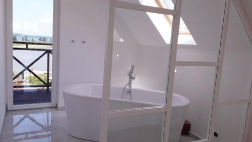 a white bath tub in a room with a window at Sterla - Masuria in Giżycko