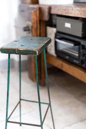a green stool sitting in front of a microwave at ManillaHouse in Montepulciano