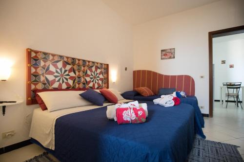 two beds in a hotel room with blue sheets at Bella Vista b&b in Erice
