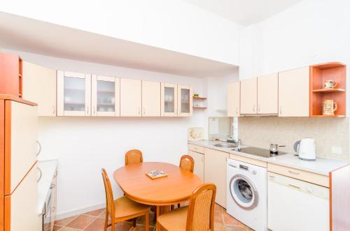 a kitchen with a wooden table and a laundry room at Stone House DiMaTo in Gruda