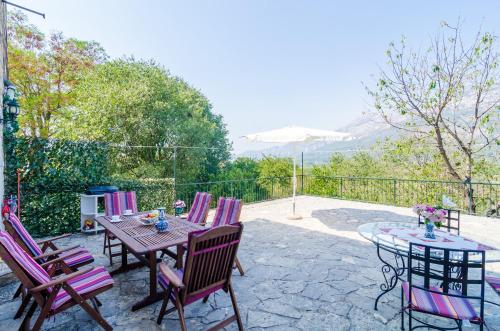 a patio with a wooden table and chairs and a table and a table and chairs at Stone House DiMaTo in Gruda