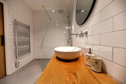 a bathroom with a white sink on a wooden counter at White Rooms Zadar345 in Zadar