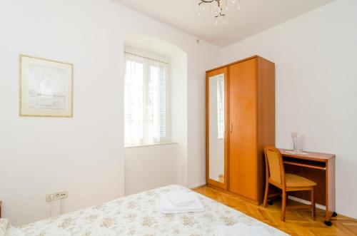 a bedroom with a bed and a desk and a chair at Stone House DiMaTo in Gruda