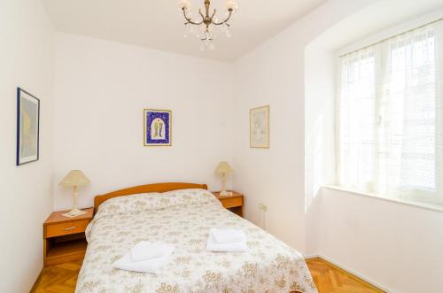 a bedroom with a bed and a window and a chandelier at Stone House DiMaTo in Gruda