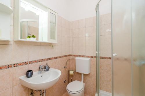a bathroom with a toilet and a sink and a shower at Stone House DiMaTo in Gruda