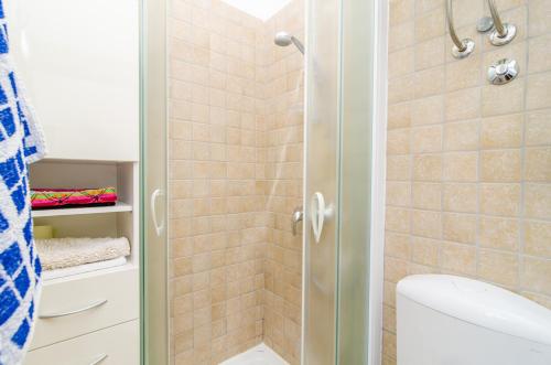 a bathroom with a toilet and a glass shower door at Stone House DiMaTo in Gruda