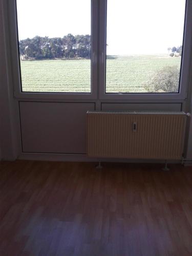 an empty room with two large windows and a field at Natur-Freude-18 in Kotzen