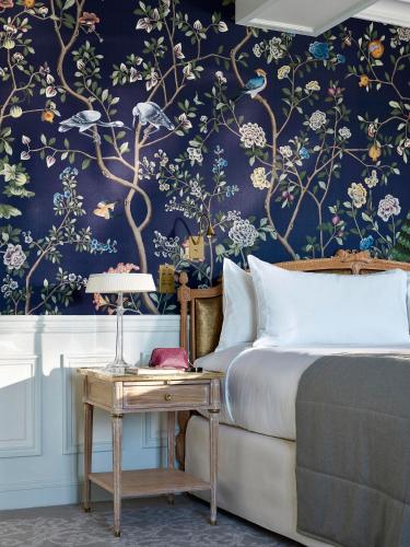 a bedroom with a bed with a floral wallpaper at Le Meurice – Dorchester Collection in Paris