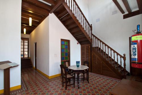a dining room with a table and a staircase at Hospedaria Abrigo De Botelho in Panaji
