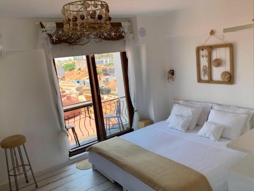 a bedroom with a bed and a large window at Vapori Otel in Bozcaada