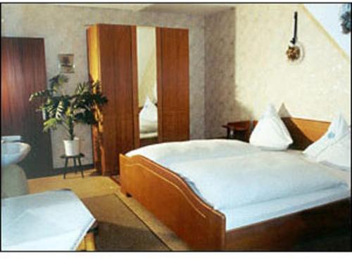 a bedroom with a large bed and a bathroom at Gästehaus Karbach in Oberwesel