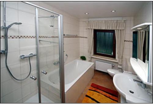 uma casa de banho com um chuveiro, uma banheira e um lavatório. em Gästehaus Karbach em Oberwesel