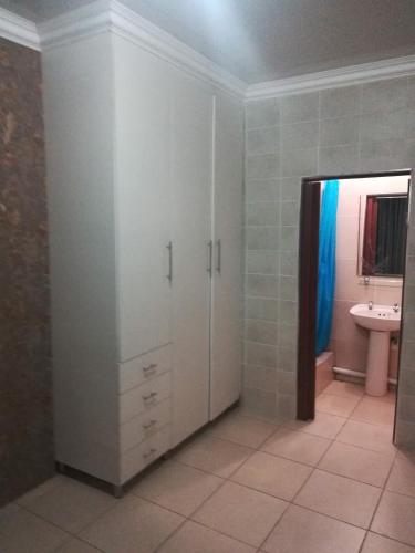 a bathroom with white cabinets and a sink at Lalela House in Johannesburg