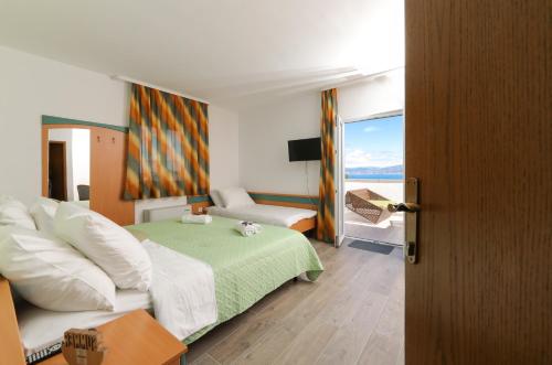 a hotel room with a bed and a view of the ocean at Downtown Private Rooms Mandić in Supetar