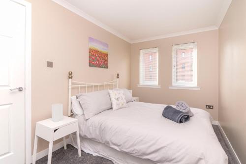 Un dormitorio con una cama blanca y una ventana. en The Cluthar - Ground Floor West End City Centre Rockvilla flat & Parking, en Glasgow