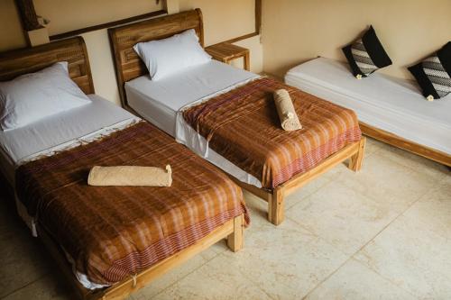 a hotel room with two beds in a room at Kalyssa Beach Bungalows in Pemuteran